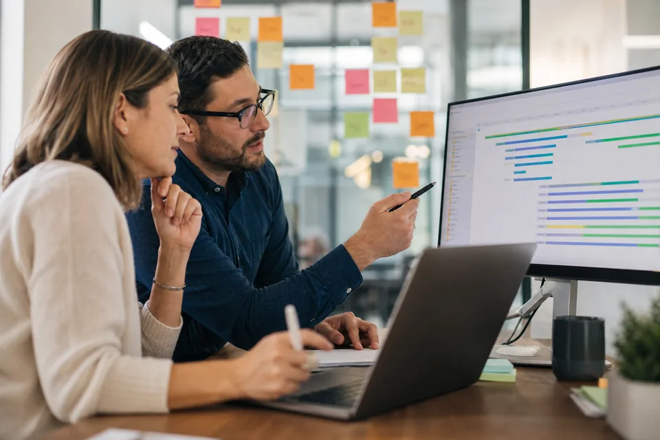 Jira administrator and PMO lead reviewing a nested portfolio hierarchy on a monitor